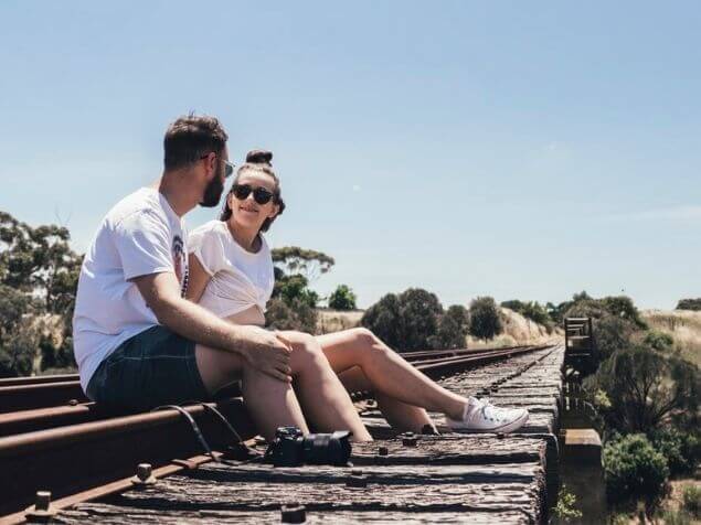 線路の上に座るカップル