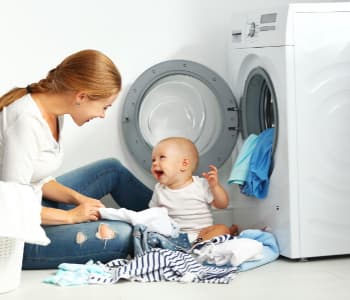 お母さんと赤ちゃんが洗濯機の前にいる